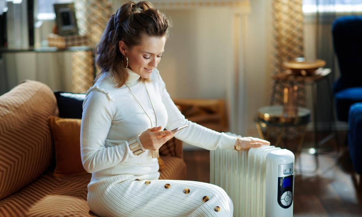 Woman tests her space heater to help ensure winter safety and comfort.